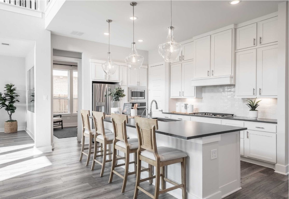 2723 Goodman Ridge Drive Rosharon, TX 77583 - Photo 7 of 15 a kitchen with stainless steel appliances granite countertop a table chairs stove and white cabinets