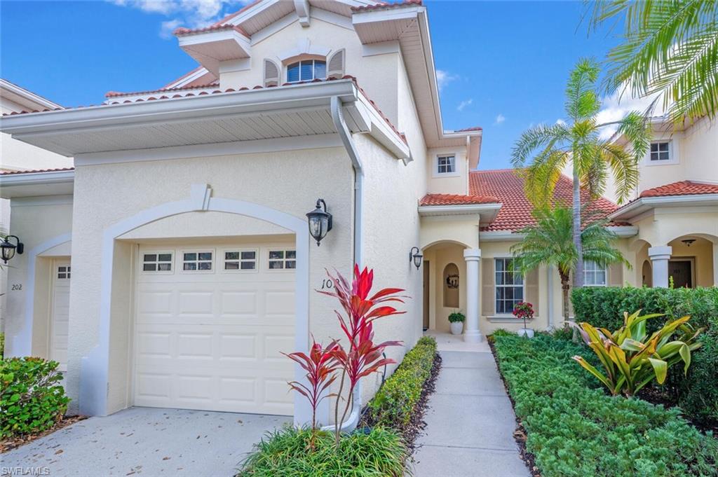 4650 Winged Foot Court, Unit 102 Naples, FL 34112 - Photo 31 of 34 View of front of home featuring an attached garage, driveway, a tiled roof, and stucco siding