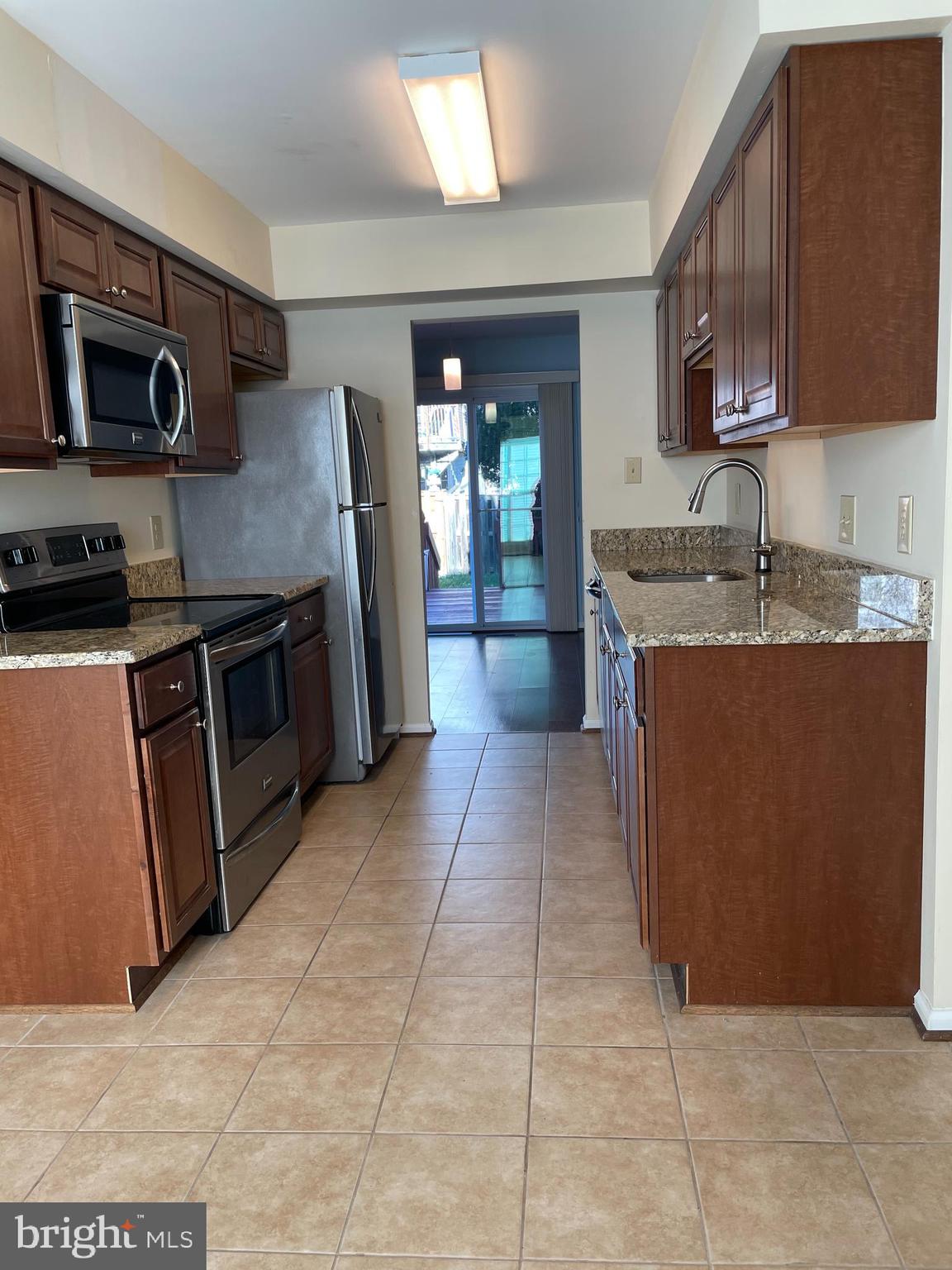 12405 Gooderham Way Gaithersburg, MD 20878 - Photo 4 of 31 a kitchen with stainless steel appliances granite countertop a stove a sink dishwasher a refrigerator and a microwave