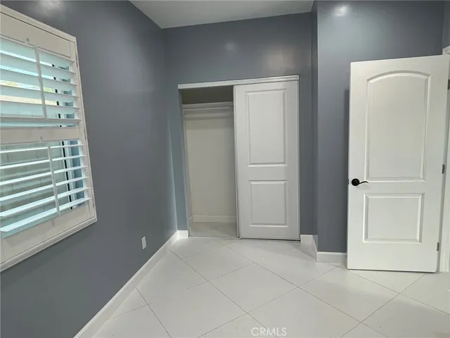 a view of an empty room with closet and a window