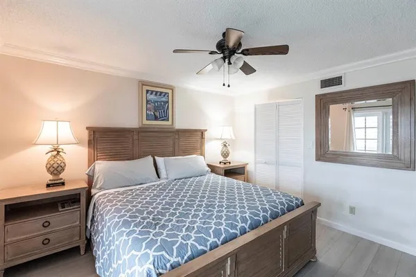a bedroom with a large bed and a chandelier