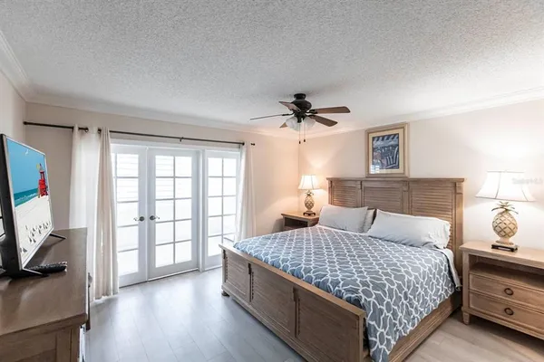 a bedroom with a large bed and a flat tv screen on dresser