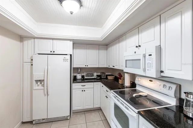 a kitchen with white cabinets and white appliances