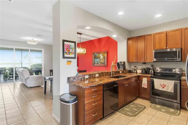 a kitchen with stainless steel appliances granite countertop a refrigerator stove top oven a sink and dishwasher