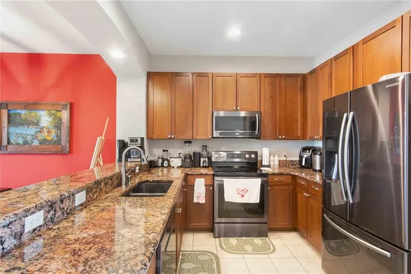 a kitchen with kitchen island granite countertop stainless steel appliances a sink cabinets and a counter top space