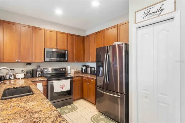 a kitchen with stainless steel appliances granite countertop a sink refrigerator and cabinets