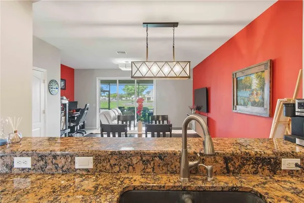 a living room with furniture a flat screen tv and kitchen view