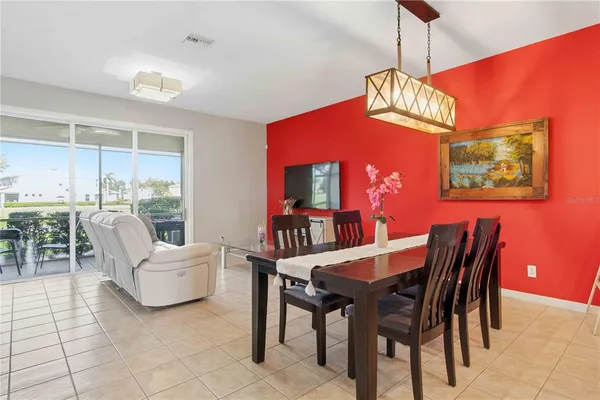 a living room with furniture a dining table and a chandelier