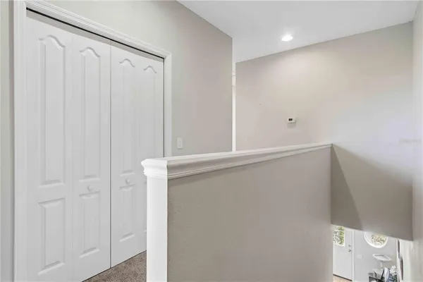 a bedroom with a bed and a chair with bookshelf