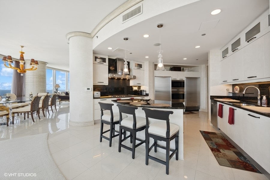 401 North Wabash Avenue, Unit 48A Chicago, IL 60611 - Photo 7 of 50 a kitchen with stainless steel appliances kitchen island granite countertop a table and chairs in it