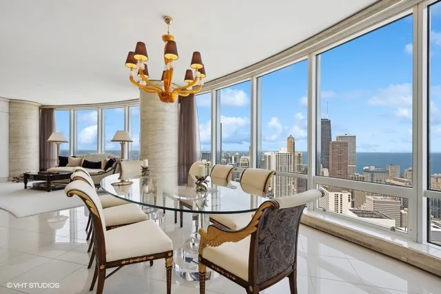 a dining room with furniture a chandelier and wooden floor