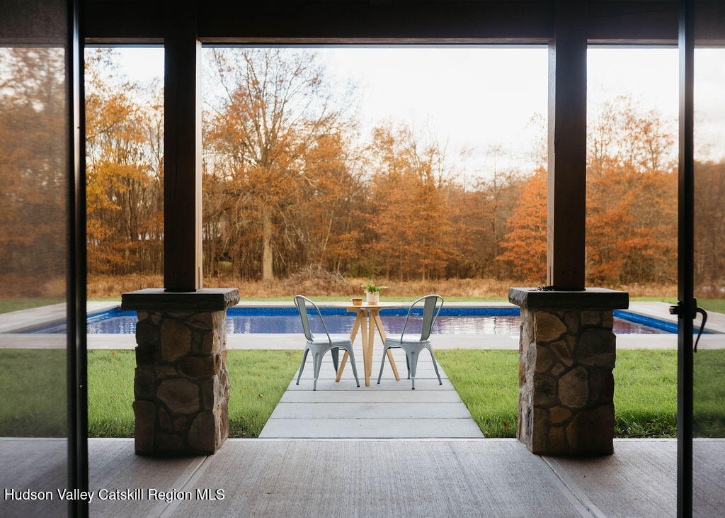 1248 Albany Post Road Gardiner, NY 12525 - Photo 29 of 44 a view of a patio with a table chairs and a floor to ceiling window