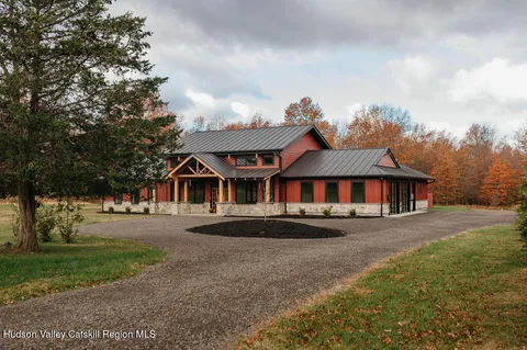 a front view of house with yard and trees in the background