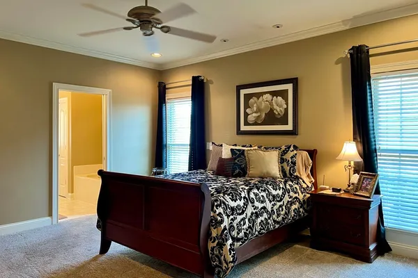 a bed sitting in a spacious bedroom next to a window