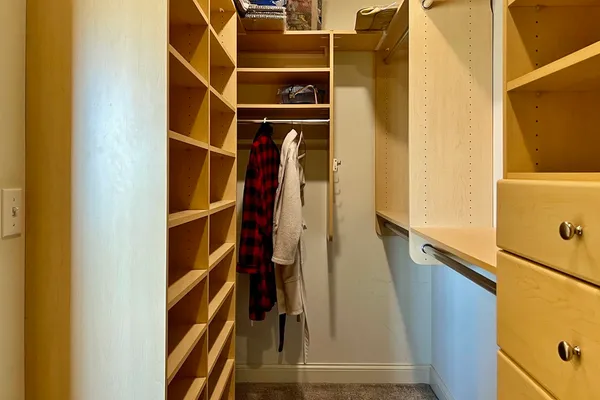 a view of walk in closet with clothes and shoes
