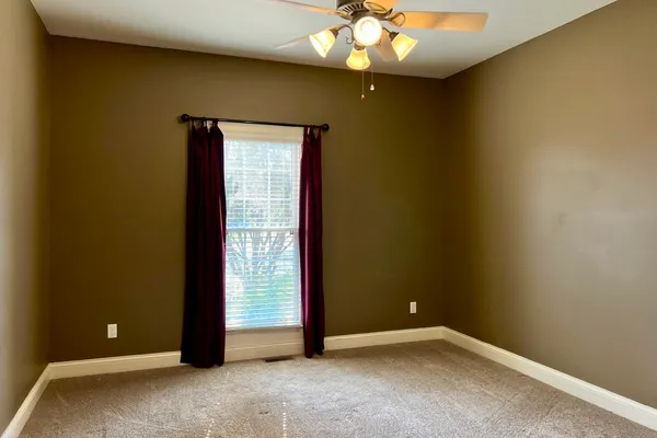 an empty room with a chandelier fan
