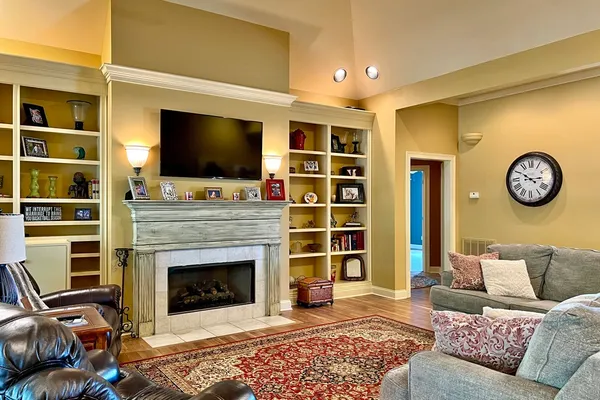 a living room with furniture a flat screen tv and a fireplace