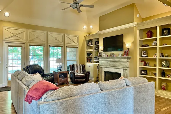 a living room with furniture a fireplace and a flat screen tv