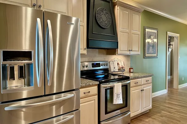 a kitchen with stainless steel appliances granite countertop a refrigerator and a stove
