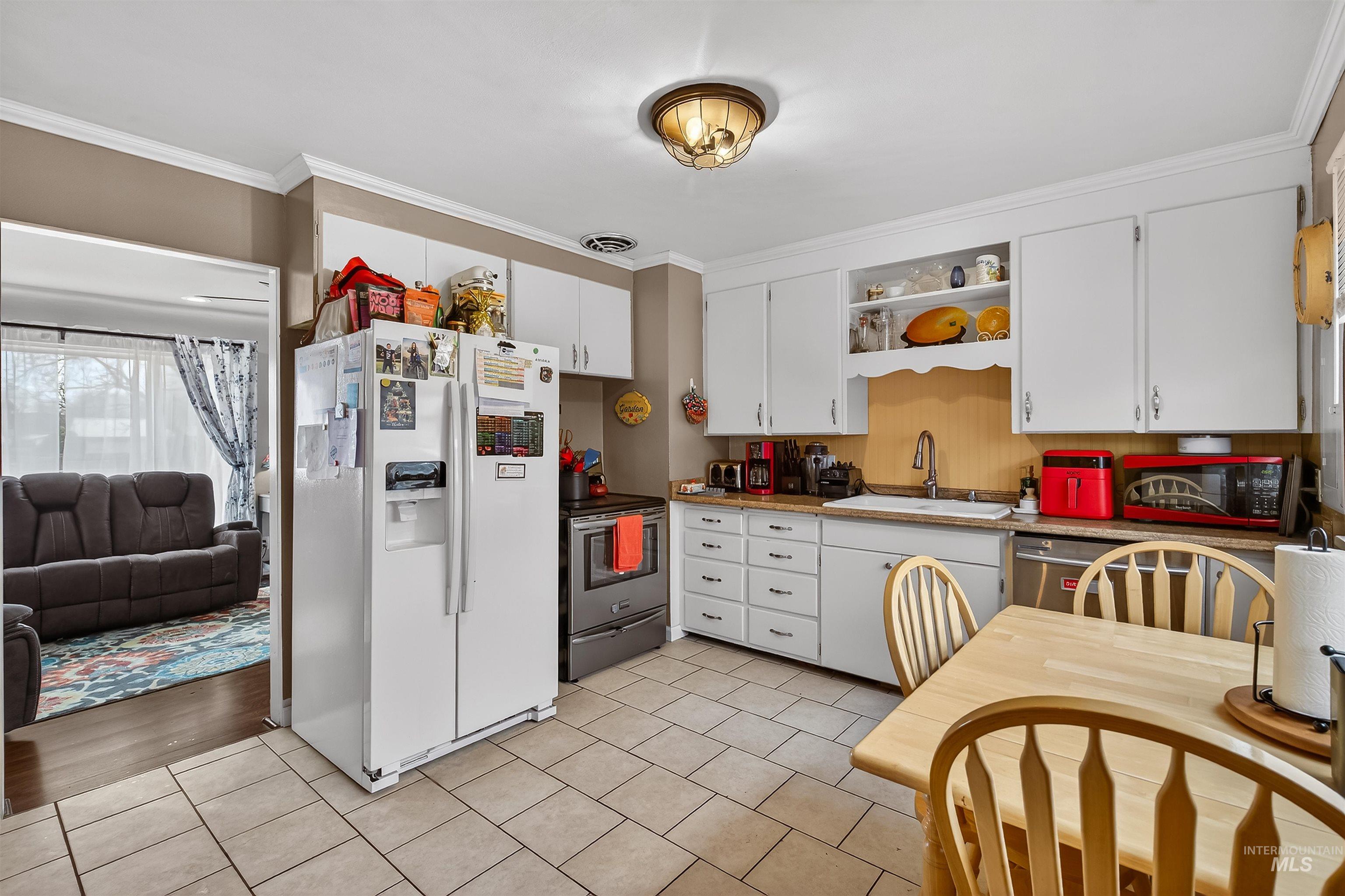 835 12th Street Clarkston, WA 99403 - Photo 14 of 39 Kitchen featuring stainless steel appliances, ornamental molding, white cabinetry, open shelves, and light tile patterned flooring