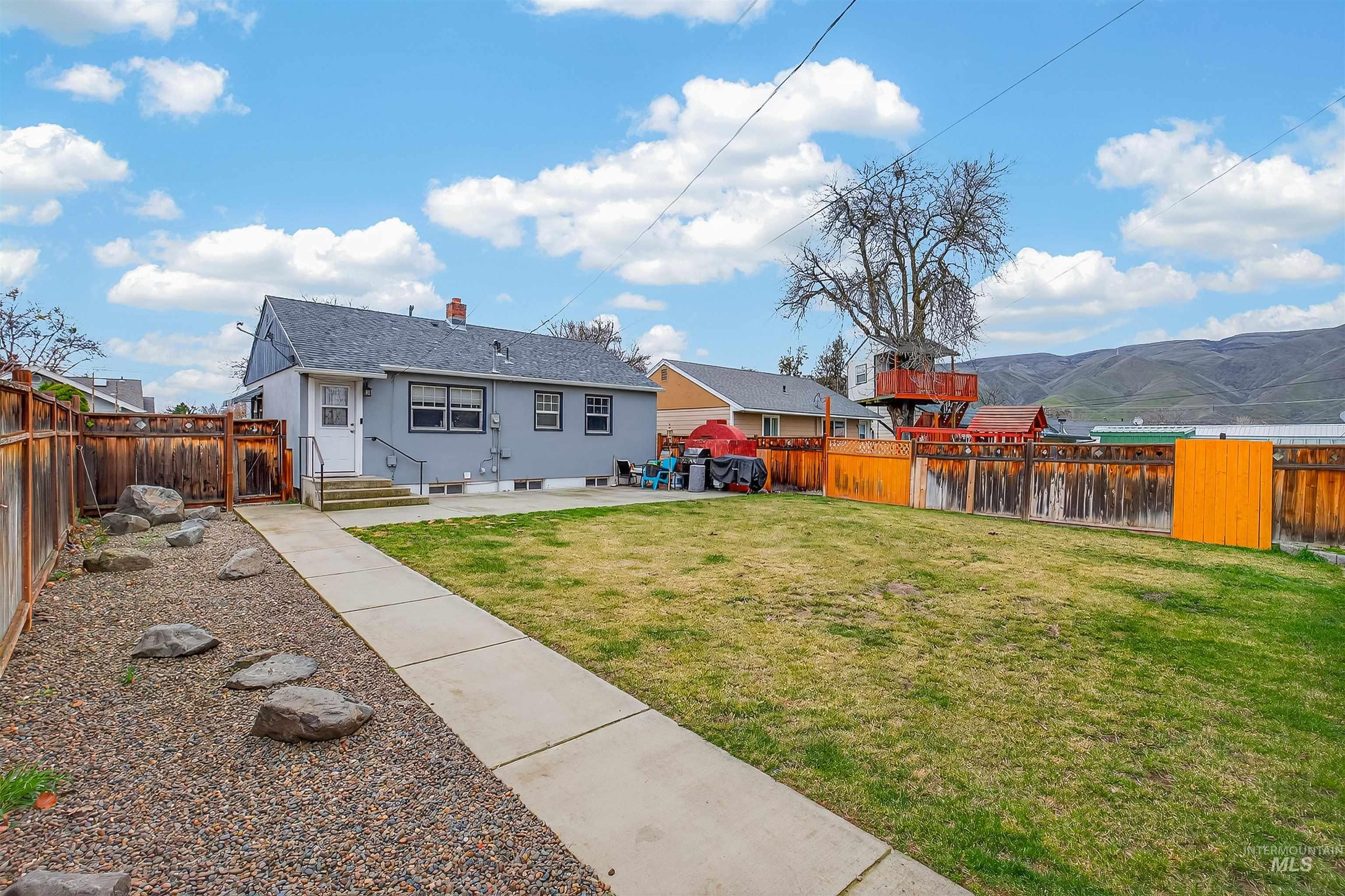 835 12th Street Clarkston, WA 99403 - Photo 29 of 39 Rear view of house featuring a patio area, a fenced backyard, and a mountain view