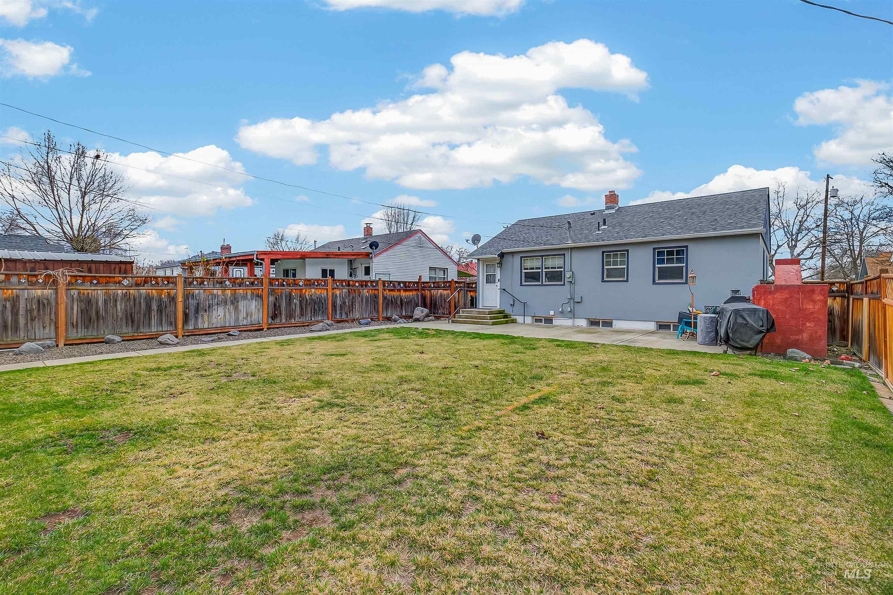835 12th Street Clarkston, WA 99403 - Photo 30 of 39 Back of property featuring a patio, a fenced backyard, and a chimney
