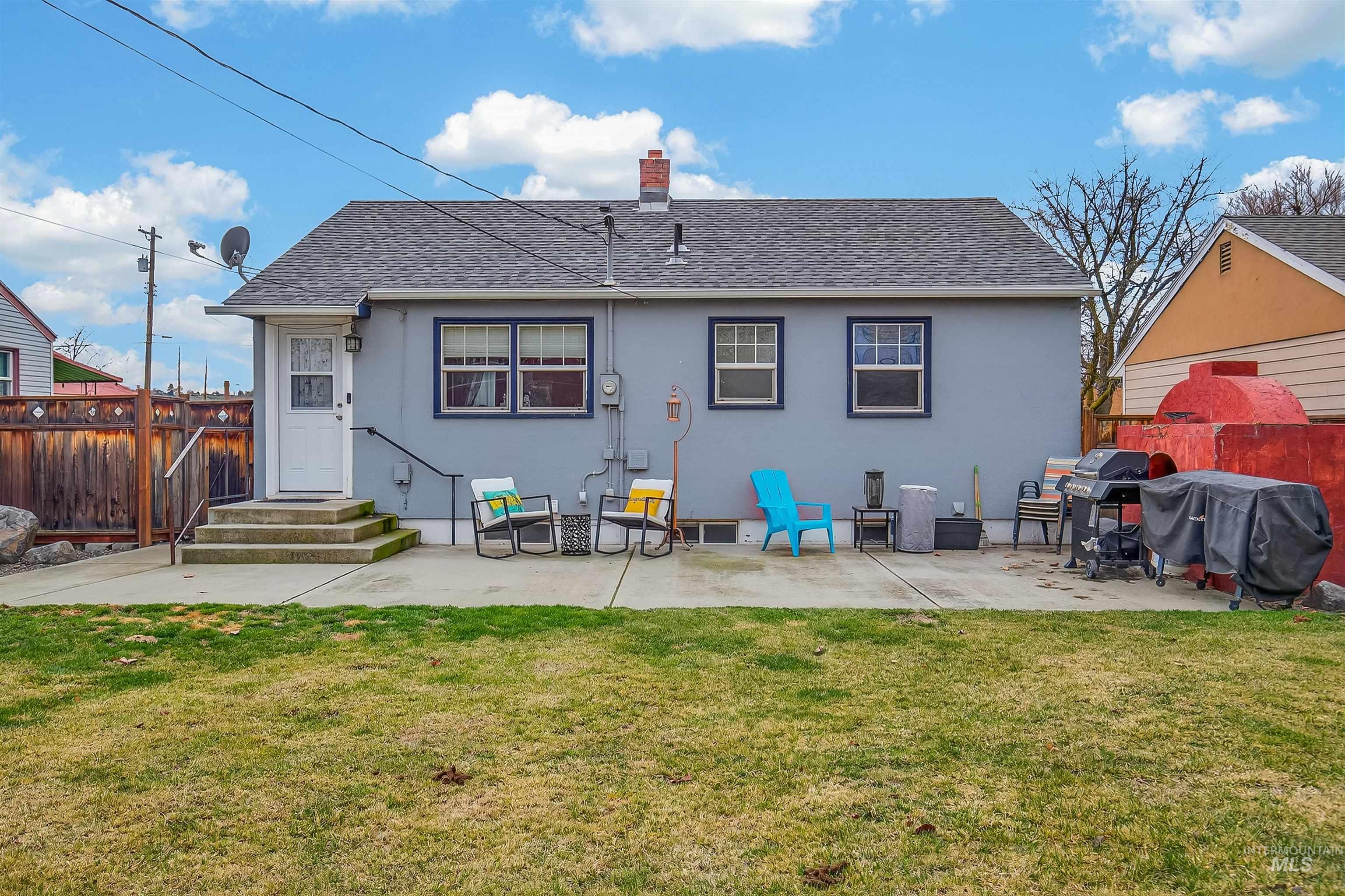 835 12th Street Clarkston, WA 99403 - Photo 38 of 39 Rear view of property featuring roof with shingles, a patio, a chimney, and stucco siding