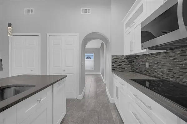 a kitchen with granite countertop a sink and a stove top oven