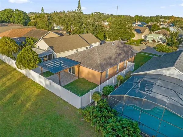 an aerial view of residential houses with outdoor space and trees