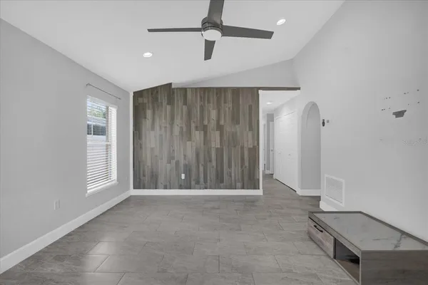 an empty room with windows and cabinet