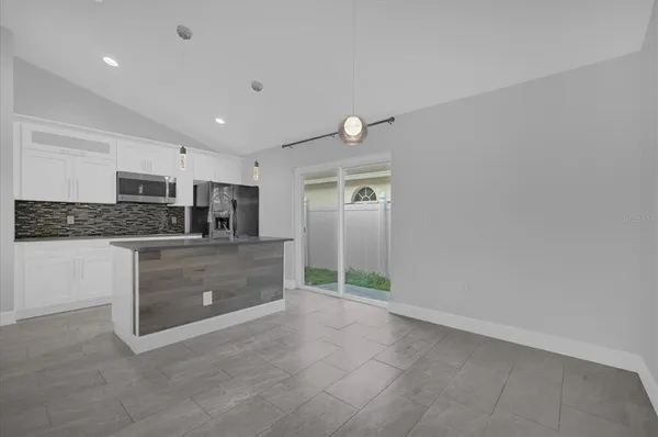 a kitchen with kitchen island white cabinets and stainless steel appliances