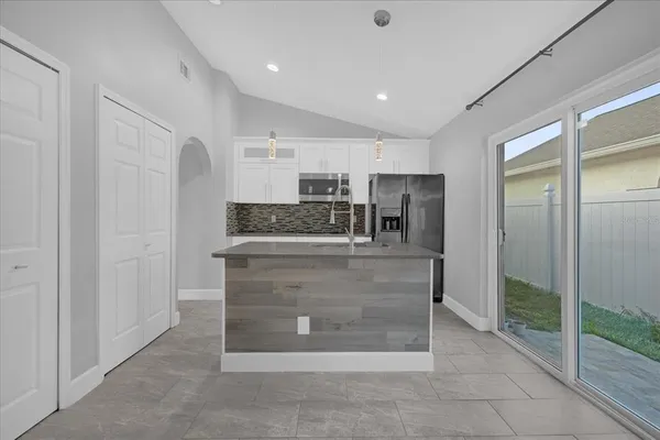 a view of kitchen with stainless steel appliances granite countertop cabinets and chandelier