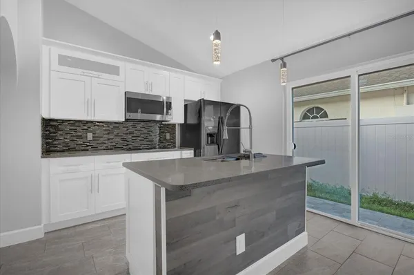 a kitchen with stainless steel appliances granite countertop a sink and a refrigerator