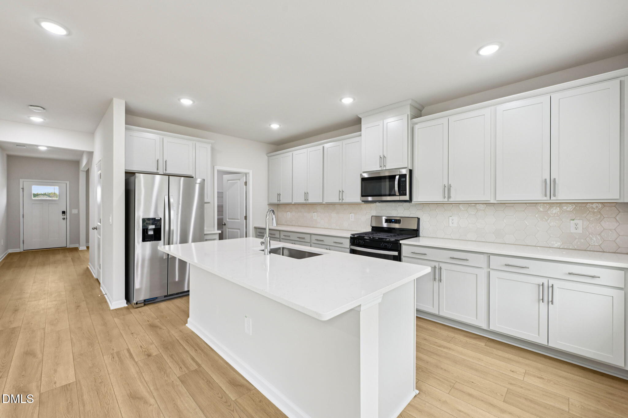 85 Thistle Patch Place Angier, NC 27501 - Photo 4 of 40 a kitchen with a sink a refrigerator a stove and white cabinets with wooden floor
