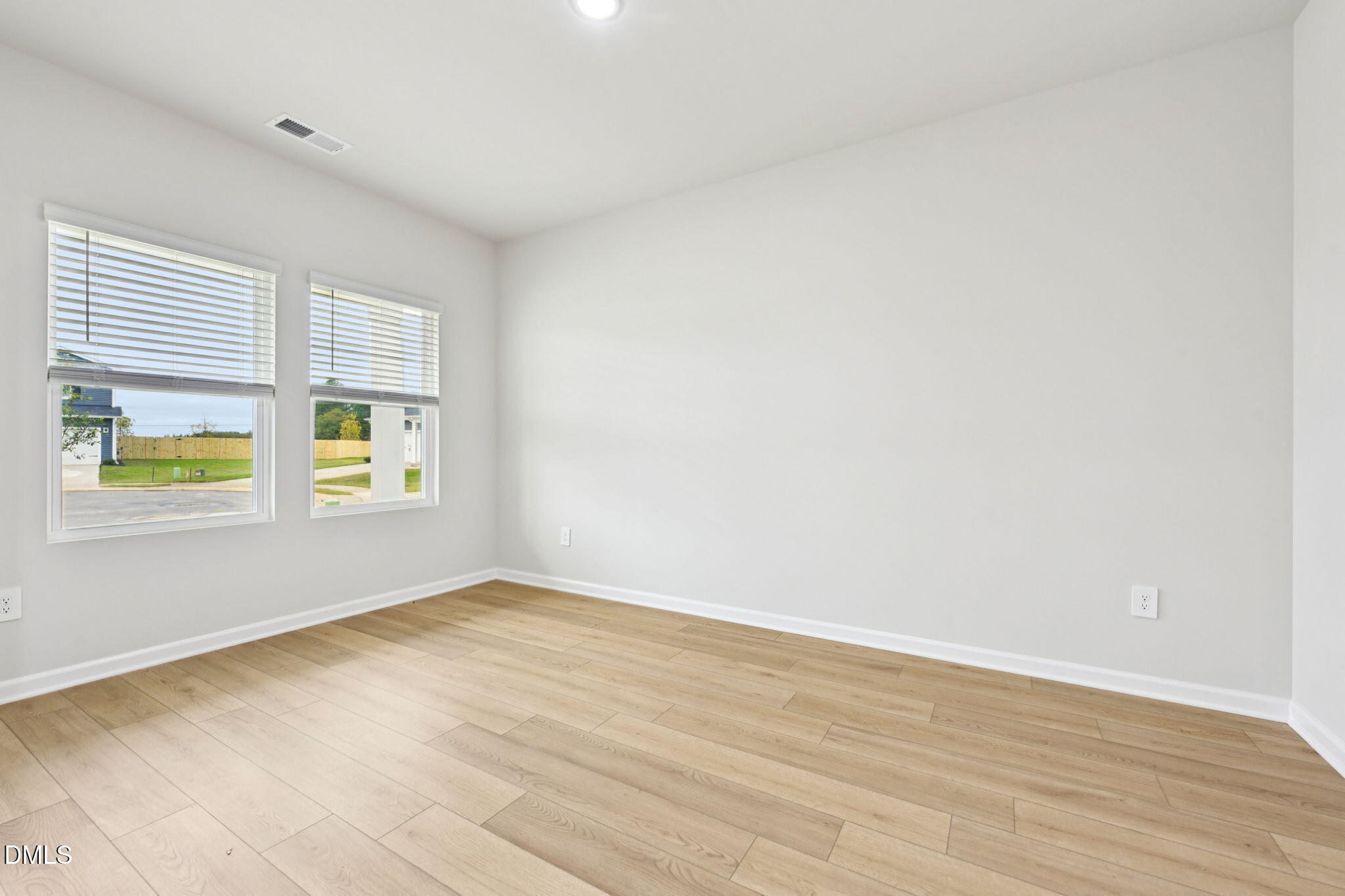 85 Thistle Patch Place Angier, NC 27501 - Photo 6 of 40 a view of an empty room with wooden floor and a window