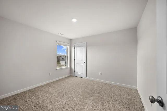 a view of an empty room with wooden floor and stairs