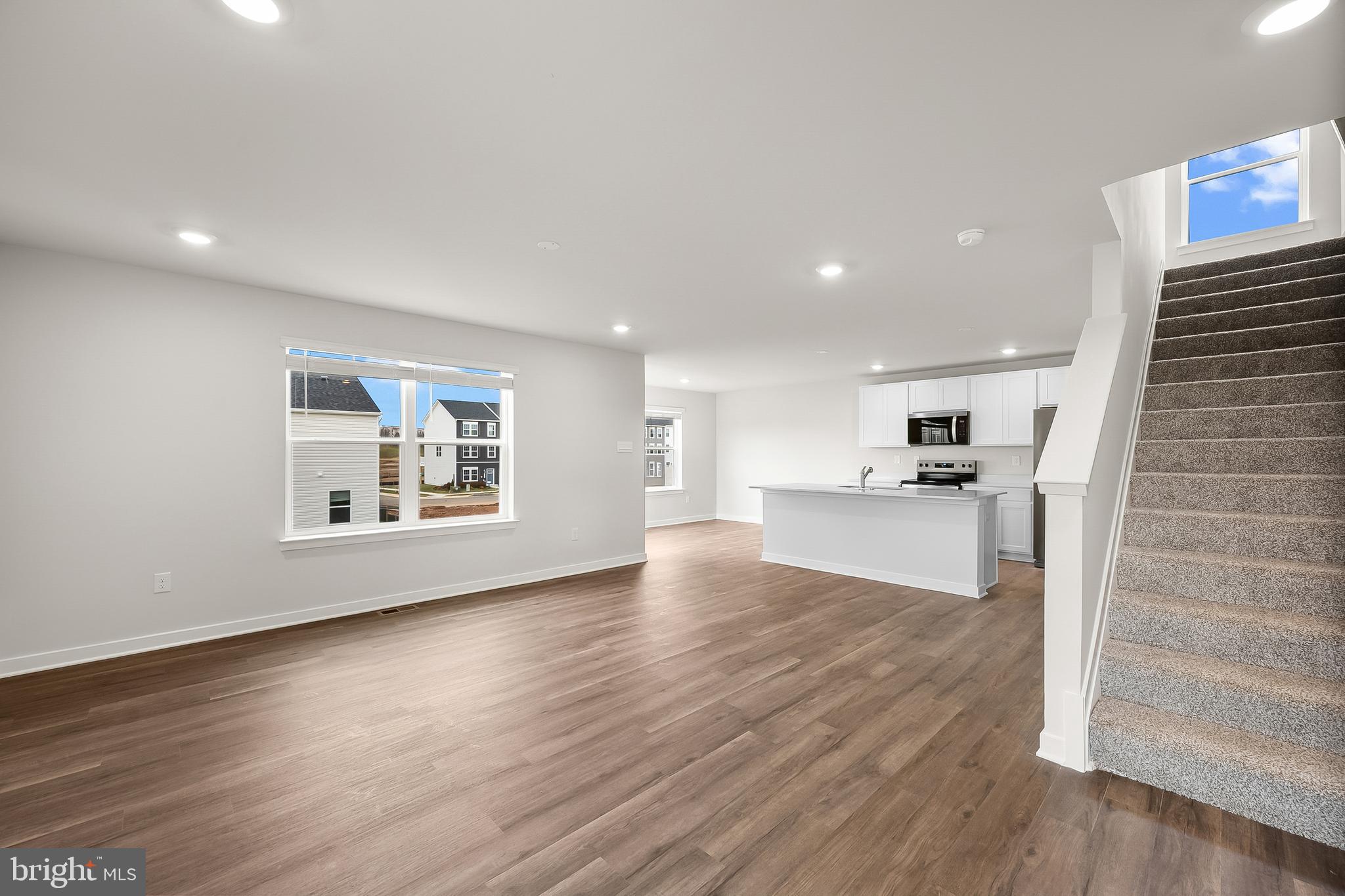 258 Eclipse Street Ranson, WV 25438 - Photo 5 of 46 a view of empty room with wooden floor and kitchen