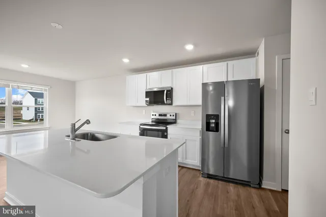 a kitchen with a sink a microwave a refrigerator and cabinets