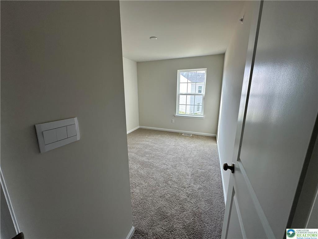 1145 Martin Road Breinigsville, PA 18031 - Photo 29 of 38 A well-lit bedroom provides a tranquil space, offering views of the neighborhood through its clear window.