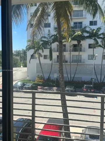 a row of palm trees sitting in front of a building