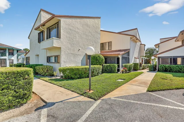 a view of a white house with a yard