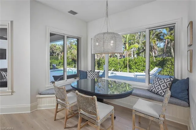 a dining room with furniture a chandelier and wooden floor