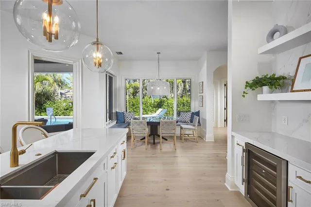 a large kitchen with kitchen island a large counter space a sink stainless steel appliances and living room view