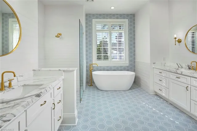 a bathroom with a double vanity sink a mirror and a bathtub