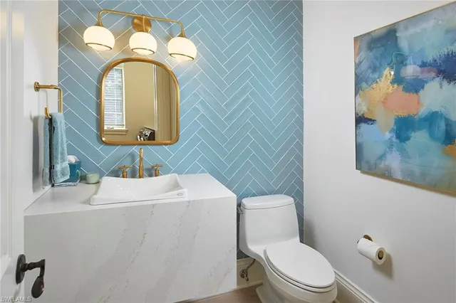 a bathroom with a toilet sink vanity and mirror