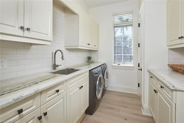a kitchen with stainless steel appliances white cabinets and a window