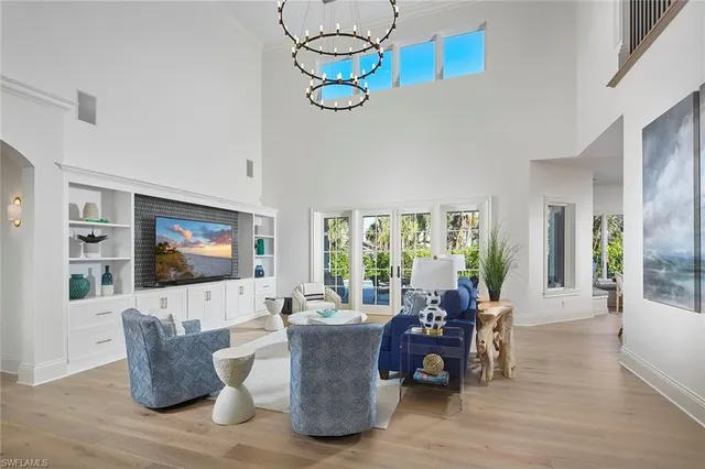 a living room with furniture a flat screen tv and floor to ceiling window