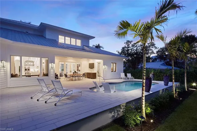 a view of a house with swimming pool and sitting area