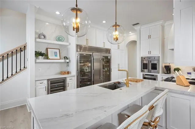 a kitchen with stainless steel appliances a table chairs and cabinets