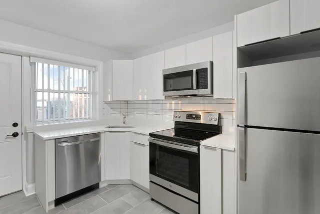 a kitchen with cabinets stainless steel appliances and counter space